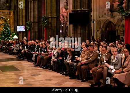 Membres de la congrégation pendant les chants royaux - ensemble au service de Noël à l'abbaye de Westminster à Londres. Date de la photo : Vendredi 8 décembre 2023. Banque D'Images