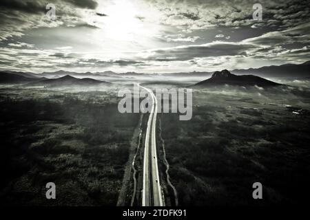 Région de Lika. Autoroute A1 et colline Zir près de la montagne Velebit dans le paysage Lika vue aérienne en noir et blanc. Croatie rurale Banque D'Images