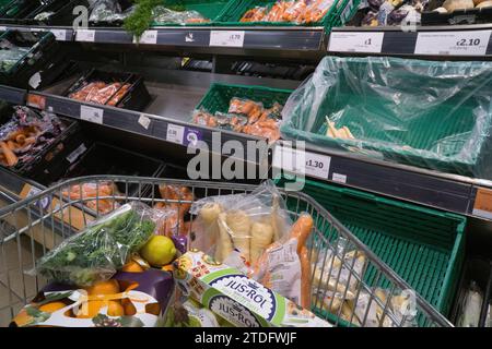 Londres, Royaume-Uni. 18 décembre 2023. Un chariot avec des plats de Noël dans un supermarché Sainsbury's à Balham. Sur les étagères au-delà du chariot se trouvent des carottes et des panais. Crédit : Anna Watson/Alamy Live News Banque D'Images