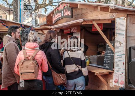 Sarlat-la-Canéda, Nouvelle-Aquitaine, France - 23 décembre 2023 : les gens font la queue à un étal vendant des galettes et des crêpes au marché de Noël de sa Banque D'Images