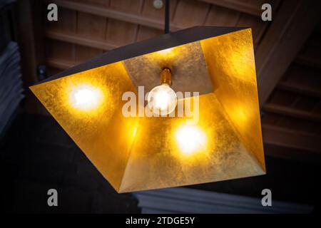 Lustre moderne suspendu au plafond avec feuille d'or et une forme simple et une seule lampe brille de lumière chaude Banque D'Images