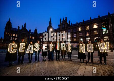 Londres, Royaume-Uni. 18 décembre 2023. Une veillée CeasefireNOW devant le Parlement pour pousser le gouvernement britannique à appeler à un cessez-le-feu durable en Israël/Gaza. La campagne a vu plus de 3 millions de personnes appeler à un cessez-le-feu immédiat et permanent, sans lequel il est impossible d’atteindre plus de 2 millions de personnes piégées à Gaza sans accès à l’eau potable, à la nourriture, aux soins de santé, à un abri adéquat et à des installations sanitaires. La veillée a été organisée par Oxfam, Care International, Save the Children et d'autres. Crédit : Guy Bell/Alamy Live News Banque D'Images