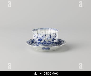 Tasse en forme de cloche et soucoupe avec poissons, crabes et plantes aquatiques, anonyme, c. 1680 - c. 1720 tête en forme de Klock et soucoupe en porcelaine avec mur modelé, peinte en bleu sous-couche. Sur le plat du plat au centre un double médaillon avec un crabe entre les plantes aquatiques ; quatre poissons entre les plantes sur le mur. L'arrière avec quatre objets de valeur (perle, fenêtre, livres, fenêtre ouverte). Marqué sur le dessous avec une marque de sceau dans un double cercle. La tête avec la même décoration. Bleu blanc. Porcelaine de Chine. glaçage. Cobalt (minéral) peinture / vitrification tête en forme de Klock et soucoupe de porcelaine avec Banque D'Images