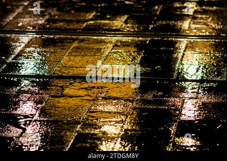 Rendu abstrait du pavement lisse de Jaffa Road dans le centre-ville de Jérusalem illuminé par une lumière artificielle lumineuse et colorée par une nuit d'hiver pluvieuse Banque D'Images