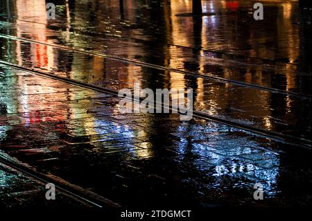 Rendu abstrait du pavement lisse de Jaffa Road dans le centre-ville de Jérusalem illuminé par une lumière artificielle lumineuse et colorée par une nuit d'hiver pluvieuse Banque D'Images