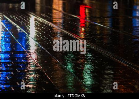 Rendu abstrait du pavement lisse de Jaffa Road dans le centre-ville de Jérusalem illuminé par une lumière artificielle lumineuse et colorée par une nuit d'hiver pluvieuse Banque D'Images