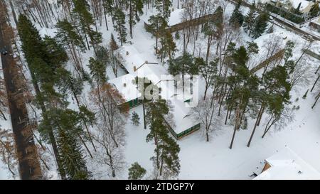 Photographie par drone de vieille maison en bois abandonnée dans une forêt pendant la journée d'hiver Banque D'Images