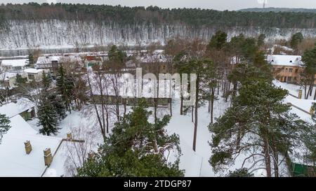 Photographie par drone de vieille maison en bois abandonnée dans une forêt pendant la journée d'hiver Banque D'Images