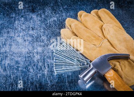 Paire de clous de construction de gants de protection en cuir et marteau de griffe sur fond métallique rayé copie image espace concept de construction Banque D'Images