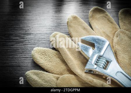 Gants de protection pour clé réglable sur planche de bois Banque D'Images