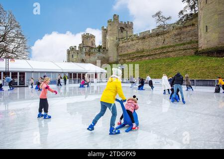 Les gens patinent sur la patinoire artificielle mobile temporaire dans le cadre du marché de Noël festif au château de Warwick Warwickshire Angleterre Royaume-Uni Banque D'Images