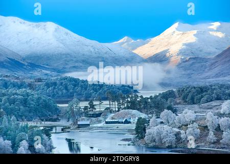 Glen Affric Cannich Écosse tôt le matin d'hiver soleil et collines enneigées avec une brume dense sur le Loch et le gel couvrant le pin et le bouleau Banque D'Images