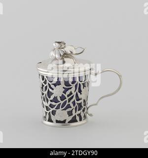 Pot à moutarde avec paroi ajourée avec branches de fleurs gravées, Gerrit Wilhelm Angermond (attribué à), 1774 le pot à moutarde, qui est équipé d'une boîte intérieure en verre bleu, a une oreille courbée en S et un couvercle articulé. La carrosserie de l'aile droite s'élargit vers le haut. Il est fermé par une arête de profil sur les arêtes supérieure et inférieure. Le mur est entièrement ouvert avec des branches de fleurs gravées. L'oreille moulée, décorée de volutes de curling, est lancée irrégulièrement. Le couvercle voûté a une décoration gravée de vignes de feuilles avec une fleur. Dans le bord, il y a un renfoncement pour une cuillère qui coupe à travers cette décoration. Le couvercle moulé bu Banque D'Images