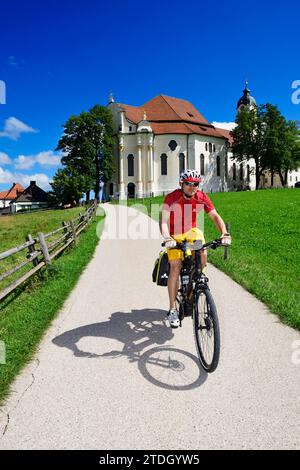 Cycliste avec vélo de randonnée devant la Wieskirche, Steingaden, haute-Bavière, Bavière, Allemagne Banque D'Images