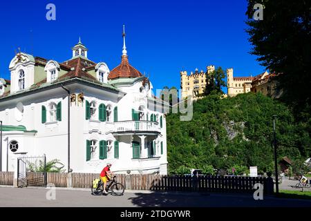 Cyclistes devant l'Hôtel Jaegerhaus et le château de Hohenschwangau, haute-Bavière, Bavière, Allemagne Banque D'Images