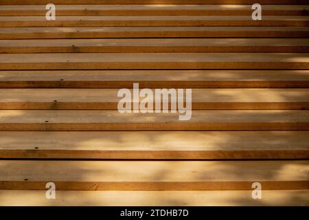 Symphonie abstraite de planches de bois, gracieusement arrangées en harmonie décalée, peinte par les douces ombres projetées par le feuillage aérien - une poésie visuelle. Banque D'Images