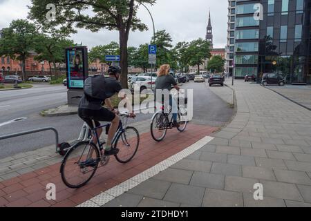 Cyclistes sur la piste cyclable à bandes rouges sur un sentier pédestre à Hambourg, en Allemagne. Banque D'Images