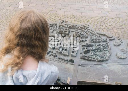 Une jeune fille regarde une carte miniature du centre-ville de Brême en Allemagne Banque D'Images