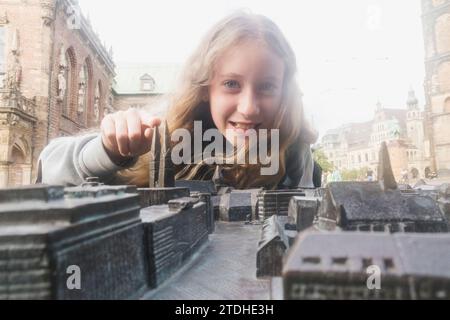 Une jeune fille regarde une carte miniature du centre-ville de Brême en Allemagne Banque D'Images