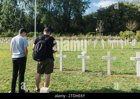 Un père et son fils rendent hommage et en apprennent plus sur les soldats de la seconde Guerre mondiale à Dunkerque, en France, dans un cimetière. Banque D'Images