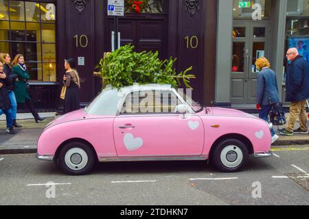Londres, Angleterre, Royaume-Uni. 18 décembre 2023. Une voiture rose garée dans le centre de Londres avec un arbre de Noël sur son toit. (Image de crédit : © Vuk Valcic/ZUMA Press Wire) USAGE ÉDITORIAL SEULEMENT! Non destiné à UN USAGE commercial ! Banque D'Images