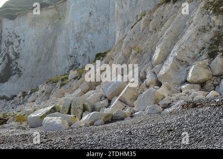 Rochers de pierre de craie blanche et rochers sur la plage à la base des falaises blanches de Douvres Banque D'Images