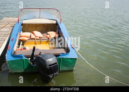 Bateau sur la jetée. Bateau de sauvetage à la jetée. Moteur sur un bateau. Gilets de sauvetage dans le bateau. Banque D'Images