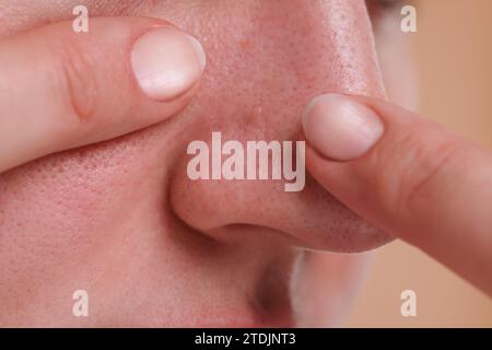 Femme qui fait sauter le bouton sur son nez, gros plan Banque D'Images