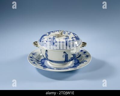 Bol couvert avec support avec des femmes dans un paysage, anonyme, c. 1700 - c. 1724 viennent avec un couvercle et underput de porcelaine avec des oreilles en forme de fleur et bouton en forme de fleur en biscuit, peint en bleu underlaze. Sur le bol une représentation continue d'une terrasse clôturée avec deux fois deux femmes (lèvres longues), palmier et bananier ; le couvercle avec la même décoration, maintenant l'une des femmes avec ventilateur ; le plat avec la même décoration, maintenant quatre palmiers et deux bananiers; sur le dos trois branches de pêche. Sur le dessous du bol et le plat marqué avec la marque à six caractères de Banque D'Images