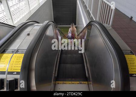 Femme descendant les escalators à la station metromover, Miami, Floride, USA Banque D'Images