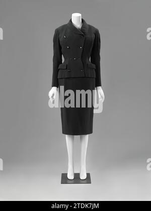 Robe et Veste (complet), Catharina Kruysveldt-de Mare, c. 1952 Veste en laine noire, courte et taillée avec manches longues et poches latérales. Modèle : (B) collier de châle plat. Manches longues assez fermées avec fente sur le poignet, ce qui ferme la drogue de trois nœuds. Poches latérales avec valves de poche contrefaites. Faux fendu au milieu. Fortement ajusté, dont les coupes sont prises en compte dans la découpe des bâtiments avant. Fermeture au moyen de quatre nœuds. licencié : AmsterdamParis Whole : Wool Laren Veste en laine noire, courte et taillée avec manches longues et poches latérales. Modèle : (B) plat Banque D'Images