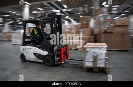 PRODUCTION - 07 décembre 2023, Hesse, Francfort-sur-le-main : un employé conduit un chariot élévateur dans le hall de fret aérien DB Schenker à Cargo City South à l'aéroport de Francfort (tourné avec une vitesse d'obturation plus lente). Le fret aérien permet de transporter une grande variété d’objets sur les continents. À l'approche de Noël, les choses doivent bouger particulièrement vite. (À dpa « quand chaque centimètre compte - poussée de fin d'année dans le hall de fret aérien ») photo : Arne Dedert/dpa Banque D'Images