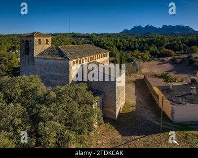 Vue aérienne de l'église de Sant Salvador de Guardiola un après-midi d'hiver. En arrière-plan, la montagne de Montserrat (Bages, Barcelone, Espagne) Banque D'Images