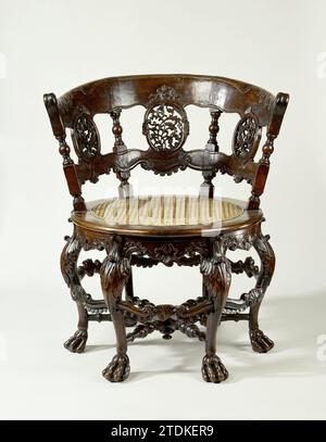 Chaise, ronde, sur six pieds en forme de S sur griffes, avec travail de feuilles poignardées et motifs rocaille. Dos avec quatre styles entre lesquels trois champs avec travail de feuille ajourée., Anonyme, 1750 chaise de bois tropical. Les six pattes en forme de S sur les griffes sont décorées au-dessus des gonflements avec un travail de feuilles poignardées et sont reliées en bas par une croix placée en rayon. Le voor-Midden Sports montre un palmier avec rocaille-voluten. La règle festonnée de la ronde, avec des roseaux tendus de fenêtre assise est décorée de motifs rocaillem. Le dos se compose de quatre styles avec maison et section et deux coquilles Saint-Jacques, entre lesquelles th Banque D'Images