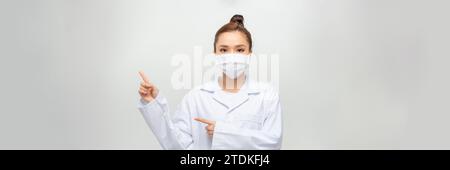 Belle femme blanche médecin dame en manteau blanc sur fond vert. points avec son f Banque D'Images