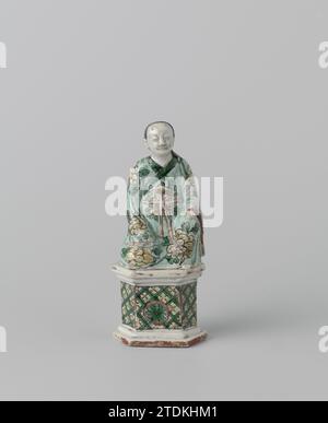 Figure d'un Chinois assis, anonyme, c. 1700 - c. 1724 image de porcelaine sur piédestal hexagonal, peinte sur biscuit en vert, jaune, aubergine et noir. Il représente une femme assise dans une robe florale. Le piédestal hexagonal est décoré à l'avant de servetwork avec un médaillon avec une fleur, deux fleurs en vrac et une fenêtre à l'arrière. Email sur biscuit avec des couleurs de distance familiale. Porcelaine de Chine. glaçage. Peinture / vitrification image de porcelaine sur piédestal hexagonal, peinte sur biscuit en vert, jaune, aubergine et noir. Il représente une femme assise dans une robe florale. La pède hexagonale Banque D'Images