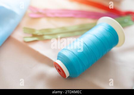 Bobines de fil pour le tissage dans les machines à coudre automatiques dans le tissu de vêtements industriels colorés sur mesure. Banque D'Images