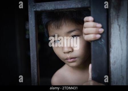 L'enfant a capturé la cage de fer avec tristesse et désespoir. Le concept de mettre fin à la violence contre les enfants et à la traite des êtres humains. maltraitance des enfants, viol Banque D'Images