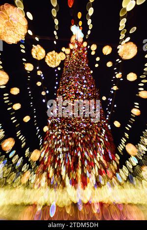 Noël et bonne année bokeh flou. Photo authentique de lumière colorée sur un arbre de noël en plein air avec bokeh. Magnifique arrière-groun bokeh de noël Banque D'Images