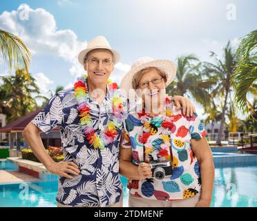 Heureux vieux couple touristes posant près d'une piscine Banque D'Images