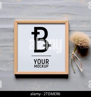 Maquette de cadre photo carré sur une table sur un fond gris avec fleur. Vue de dessus du format PSD. Pour le design, fait à la main, café, boutique, entreprise Banque D'Images