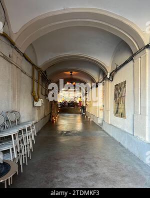 Passage voûté blanc et jaune dans le bâtiment historique, mène au restaurant. Photographie de rue. Cluj-Napoca, Roumanie Banque D'Images