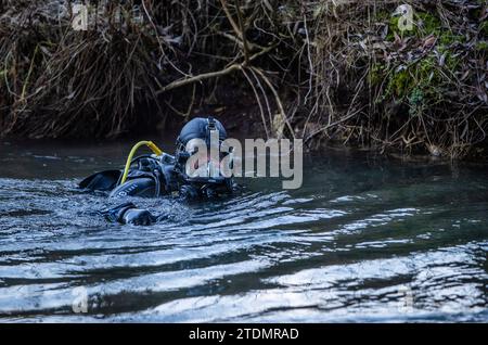 Bingen Hitzkofen, Allemagne. 19 décembre 2023. Un plongeur de police fouille les eaux du Lauchert à la recherche d’un enfant de deux ans porté disparu depuis avant-hier. La fillette de deux ans avait probablement quitté la maison de ses parents en pyjama dans un moment inaperçu dimanche après-midi. Jusqu'à présent, les fonctionnaires supposent que c'était un accident. Crédit : Christoph Schmidt/dpa/Alamy Live News Banque D'Images