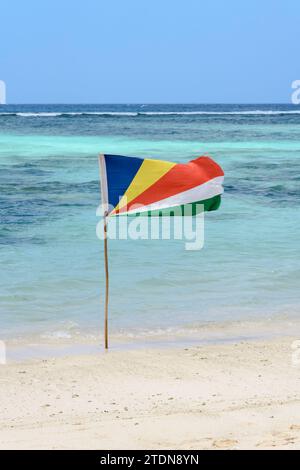 Drapeau des Seychelles sur la plage à Anse Source d'argent, île de la Digue, Seychelles, Océan Indien Banque D'Images