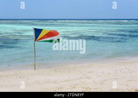 Drapeau des Seychelles sur la plage à Anse Source d'argent, île de la Digue, Seychelles, Océan Indien Banque D'Images