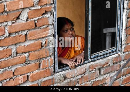Guwahati, Guwahati, Inde. 19 décembre 2023. Une femme regarde à travers la fenêtre pour voir le léopard entier s'abriter dans un bâtiment en construction à Fatashil Ambari à Guwahati Assam Inde le mardi 19 décembre 2023 (image de crédit : © Dasarath Deka/ZUMA Press Wire) USAGE ÉDITORIAL SEULEMENT! Non destiné à UN USAGE commercial ! Crédit : ZUMA Press, Inc./Alamy Live News Banque D'Images