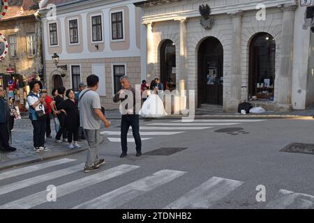 Touristes en visite guidée avec un couple ayant des photos de mariage prises en arrière-plan, dans la vieille ville, Zagreb, Croatie Banque D'Images