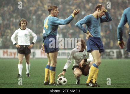 CLASSÉ - 01 mai 1974, Hambourg : le milieu de terrain allemand Günter Netzer (en bas) s'accroupie pour tirer le coup franc au Volksparkstadion de Hambourg. Son coéquipier Bernd Hölzenbein (à gauche, derrière) regarde tandis que les adversaires suédois bosse (Bo) Larsson (2e à partir de la gauche) et Ove Grahn (à droite) discutent. L'équipe nationale allemande de football a remporté le match international contre la Suède devant 55 000 000 spectateurs. Le football suédois pleure la perte de l'ancien international Bo Larsson. L'ancien joueur attaquant et participant à la coupe du monde de 1970, 1974 et 1978 est décédé à l'âge de 79 ans, comme l'a annoncé la Fédération suédoise de football O. Banque D'Images