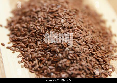 Les graines de lin brutes reposent sur une surface en bois dans la cuisine, préparées pour la cuisson. Vue de dessus. Effectuer la mise au point au centre des grains Banque D'Images