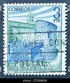 Timbre-poste annulé imprimé par l'Espagne, qui fait la promotion de l'église et de la tour à Llivia, Gérone, vers 1983. Banque D'Images